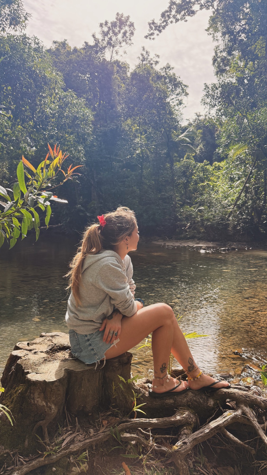 Charlotte prenant le temps d’observer la nature au bord d’une rivière